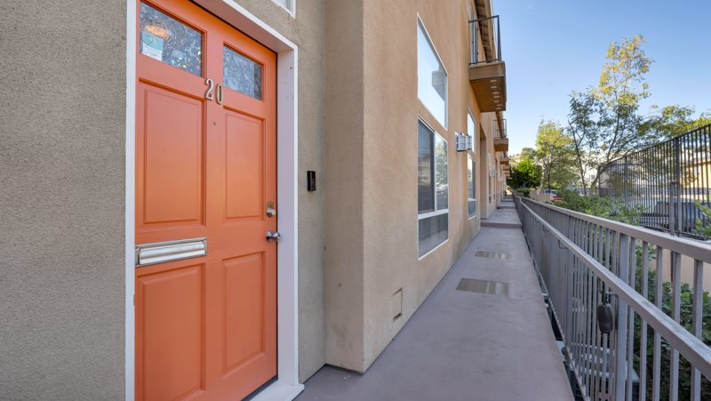 A building with a bright orange door numbered 201.